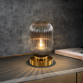 Elegante lampada da tavolo nordica con vetro curvo rigato per un'illuminazione d'atmosfera