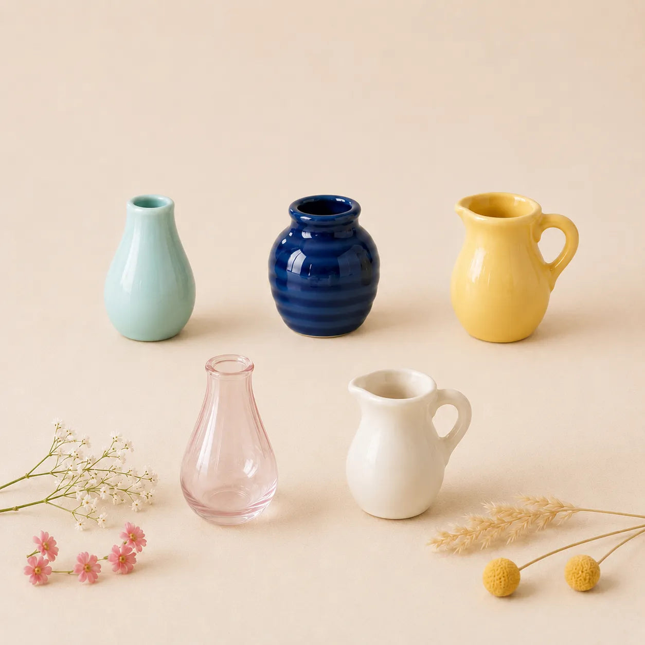 Set of colorful ceramic vases and mugs on a beige background
